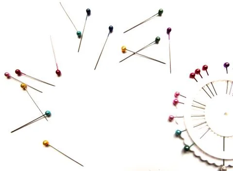 Set of sewing pins with colored beads in an white organizer on a white bg. Stock Photos