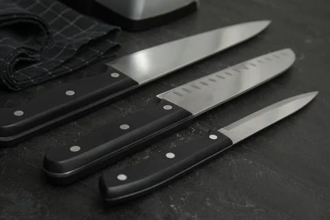 Set of sharp knives on black table, closeup Foto stock