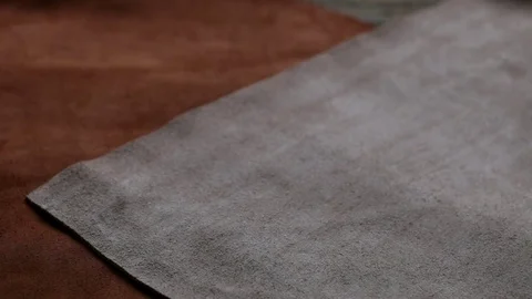 Set of sheets of brown genuine leather on wooden background Stock Footage 72397073