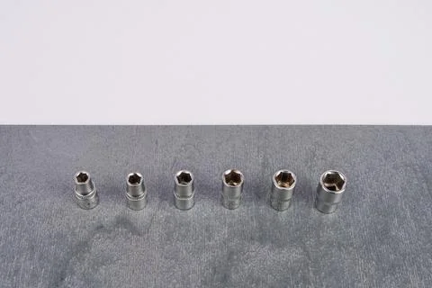 Set of six socket wrench attachments on gray surface Stock Photos