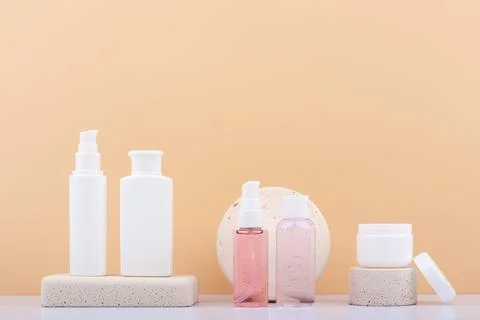 Set of skin care products on neutral stone podiums against beige background with Stock Photos
