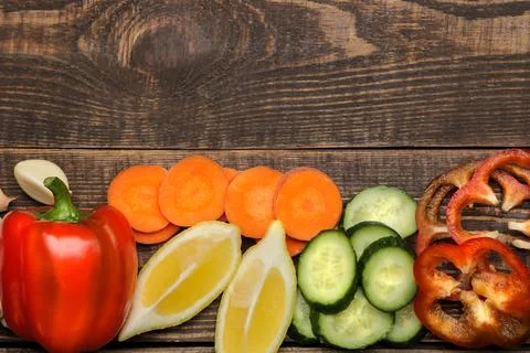 Set of sliced vegetables for making salads or other dishes on a brown wooden Stock Photos