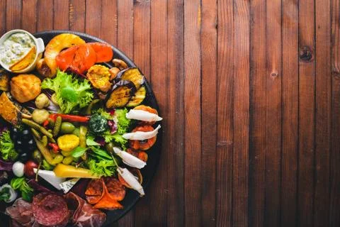 Set snacks with meat and pickled vegetables. Italian cuisine. Top view. On Wo Stock Photos