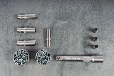 Set of socket wrench tools and screws on gray surface Stock Photos