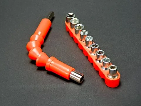 A set of socket wrenches and a flexible shaft on a dark surface, showcasing.. Stock Photos