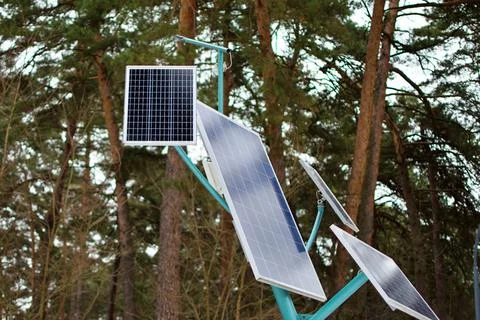 Set of solar panels on blurred background of trees Stock Photos