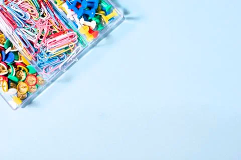 A set of stationery made of multi-colored buttons and paper clips in a box on Stock Photos