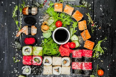 Set sushi with decor on a dark background Stock Photos