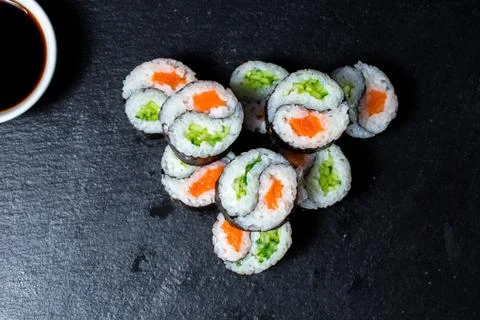 Set of sushi maki roll with sesame and soy sauce on a dark plate. Stock Photos