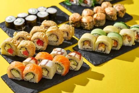 Set of sushi roll different type on a yellow background. Top view. Traditional Stock Photos