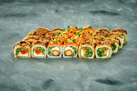Set of sushi rolls with different fillings on a gray background. Selective Fo Stock Photos