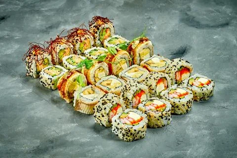 Set of sushi rolls with different fillings on a gray background. Selective Fo Stock Photos