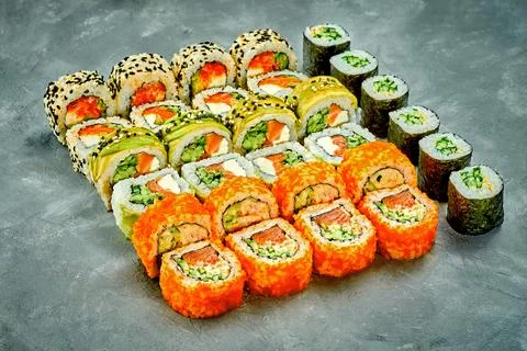 Set of sushi rolls with different fillings on a gray background. Selective Fo Stock Photos