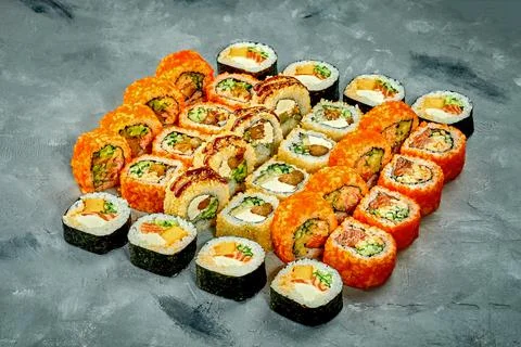 Set of sushi rolls with different fillings on a gray background. Selective Fo Stock Photos