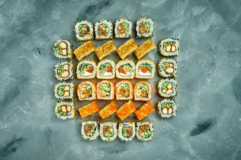 Set of sushi rolls with different fillings on a gray background. Selective Fo Stock Photos