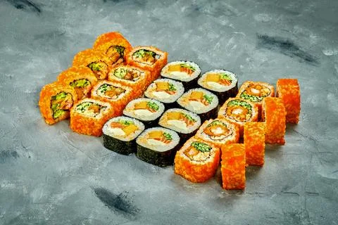 Set of sushi rolls with different fillings on a gray background. Selective Fo Stock Photos