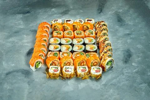 Set of sushi rolls with different fillings on a gray background. Selective Fo Stock Photos