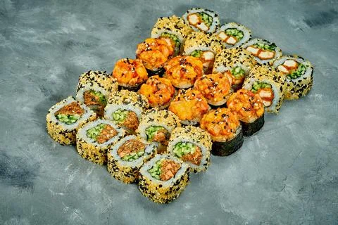 Set of sushi rolls with different fillings on a gray background. Selective Fo Stock Photos