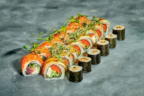 Set of sushi rolls with different fillings on a gray background. Selective Fo Stock Photos