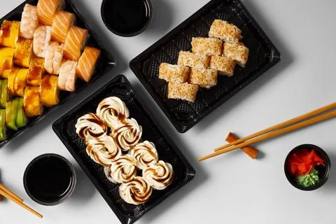 Set of sushi rolls in plastic packages on a white background. Stock Photos