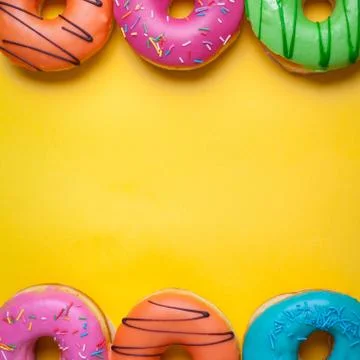 A set of sweet donuts on orange background. Top view with copy space Stock Photos