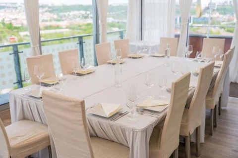 A set table with a beige tablecloth for 12 people. Panoramic view. Decanter of Stock Photos