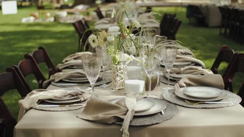 A set table decorated with fresh flowers is perfect for outdoor gatherings or Stock Footage 308859451