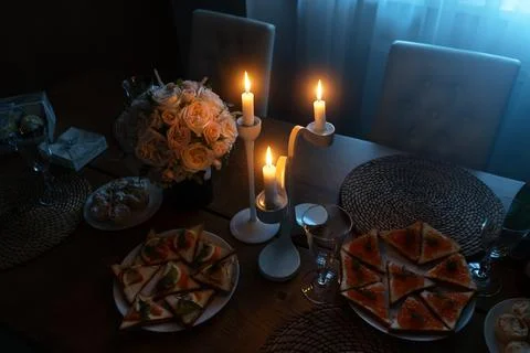 A set table with lighted candles, a romantic dinner. Stock Photos