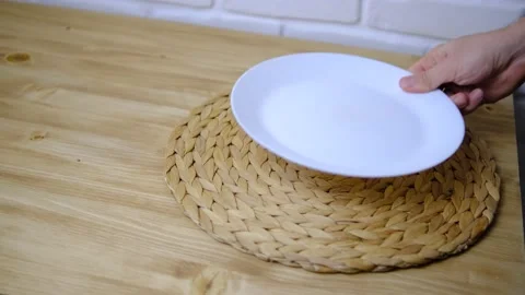 Set the table. A plate and fork were placed on the wooden table. A braided rug.  Stock Footage 147094309