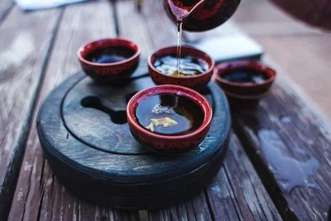Set for tea ceremony. Tea pours from a teapot into a cup. The art of the east Stock Photos