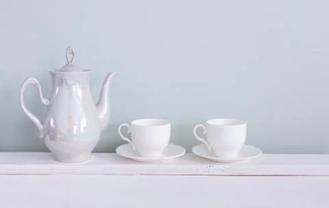Set of tea cups and  ceramic teapot  on shelf Stock Photos