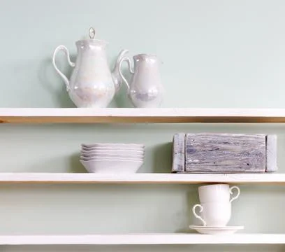 Set of tea cups and  ceramic teapot  on shelf Stock Photos