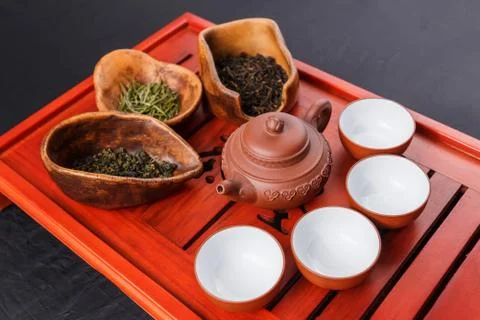 Set of teapot, three kinds of tea and four bowls Stock Photos