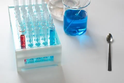 Set of test tubes in lab stand, beaker with blue liquid near, chemical anal.. Stock Photos