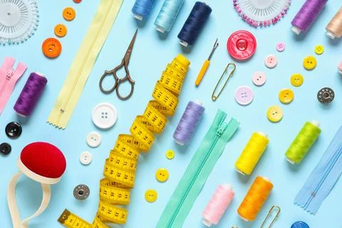 Set of thread spools with measuring tape, scissors and sewing supplies on blu Stock Photos