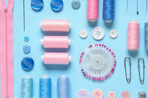 Set of thread spools with sewing supplies on blue background Stock Photos