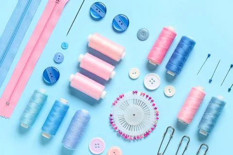 Set of thread spools with sewing supplies on blue background Stock Photos