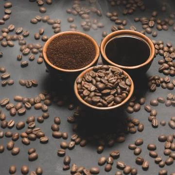 Set of three cups of coffee beans, ground and drink on a black background. Stockfoto's