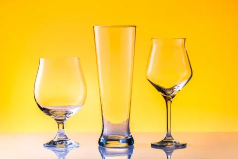 Set with three different empty beer glasses on white golden background. Alcohol Stock Photos