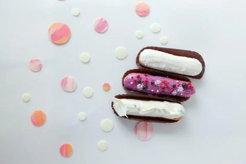 A set of three eclairs with different fillings and design isolate on a white  Stock Photos