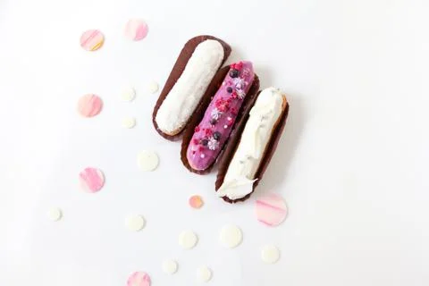 A set of three eclairs with different fillings and design isolate on a white  Stock Photos
