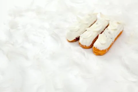 A set of three eclairs with white chocolate decor isolate on a white surface  Stock Photos