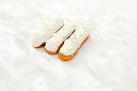 A set of three eclairs with white chocolate decor isolate on a white surface  Stock Photos