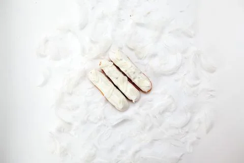 A set of three eclairs with white chocolate decor isolate on a white surface  Stock Photos