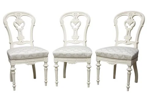 Set of three ornate, light-colored chairs with patterned upholstery. Classic  Stock Photos