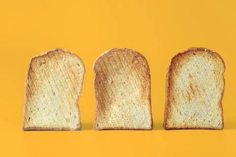 Set of three toasts isolated on yellow background. Stock Photos