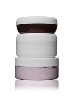 Set of three white, red, pink plastic cosmetic jars for face cream on white Stock Photos