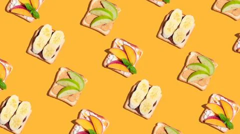 Set of toasted bread with peach, apple and banana on yellow background. Stock Photos