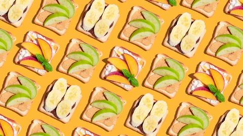 Set of toasted bread with peach, apple and banana on yellow background. Stock Photos