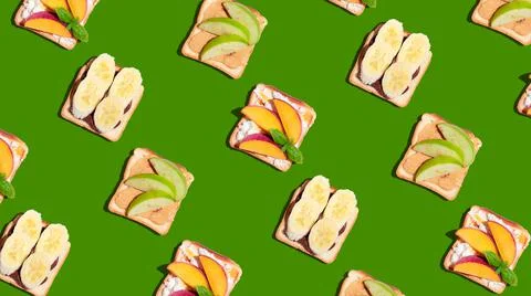 Set of toasted bread with peach, apple and banana on green background. Stock Photos
